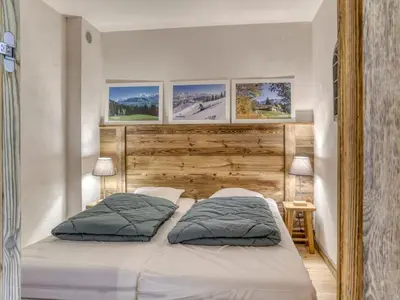 a kitchen with wooden cabinets and a table with chairs at Appartement rénové 1 chambre cabine, Megève, proche centre - FR-1-453-327 in Megève