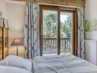 a table and chairs on a deck with a view of trees at Appartement rénové 1 chambre cabine, Megève, proche centre - FR-1-453-327 in Megève