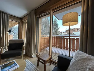 a living room with a view of a balcony at Appartement de standing 2 chambres, Wi-Fi, animaux admis, parking - FR-1-836-56 in Arâches-la-Frasse