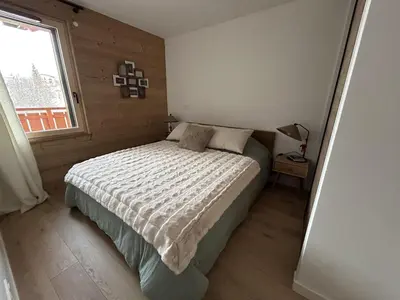 a small bedroom with a bed with a window at Appartement de standing 2 chambres, Wi-Fi, animaux admis, parking - FR-1-836-56 in Arâches-la-Frasse