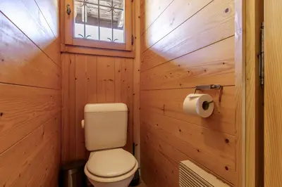 a small bathroom with a toilet and a window at Chalet de Nina in Les Houches