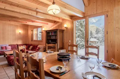 a dining room with a table and a living room at Chalet de Nina in Les Houches
