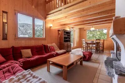 a living room with a red couch and a table at Chalet de Nina in Les Houches