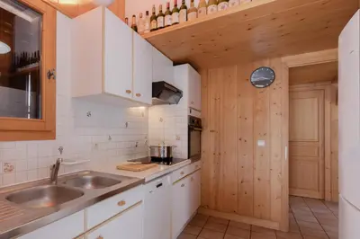 a kitchen with white cabinets and a sink at Chalet de Nina in Les Houches