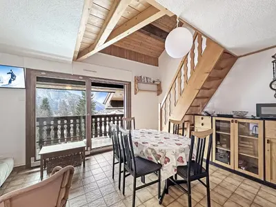 a dining room with a table and chairs and a balcony at NAN116 - Duplex 4-6 pers face a la telecabine in Les Carroz d'Araches