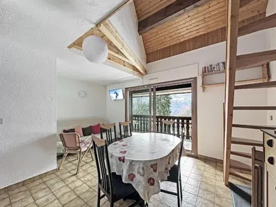 a dining room with a table and chairs and a balcony at NAN116 - Duplex 4-6 pers face a la telecabine in Les Carroz d'Araches