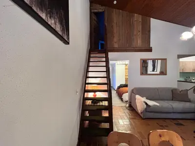 a spiral staircase in a living room with a couch at Chalet des Cinq in Samoëns