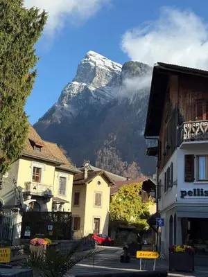 a mountain in the middle of a town with buildings at Chalet des Cinq in Samoëns