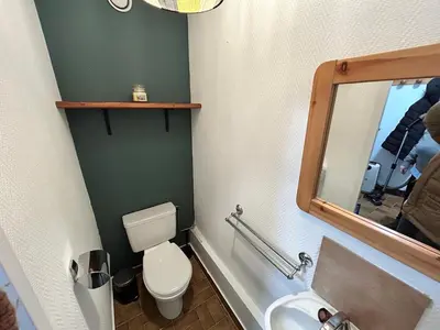 a bathroom with a toilet and a sink and a mirror at Chalet des Cinq in Samoëns