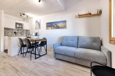 a living room with a couch and a table at Charmin Savoy - lovely 1 bedroom apartment next to Savoy ski area in Chamonix-Mont-Blanc