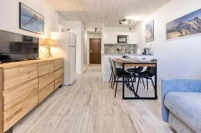 a kitchen and dining room with a table and a refrigerator at Charmin Savoy - lovely 1 bedroom apartment next to Savoy ski area in Chamonix-Mont-Blanc