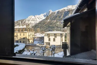 a view of a snowy mountain from a window at Charmin Savoy - lovely 1 bedroom apartment next to Savoy ski area in Chamonix-Mont-Blanc