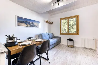 a living room with a table and a blue couch at Charmin Savoy - lovely 1 bedroom apartment next to Savoy ski area in Chamonix-Mont-Blanc