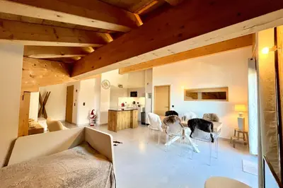a living room with chairs and a table and a kitchen at Comfortable stay 200m from the ski lifts in Combloux