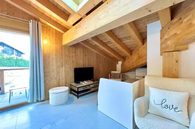 a living room with a white refrigerator and a tv at Comfortable stay 200m from the ski lifts in Combloux