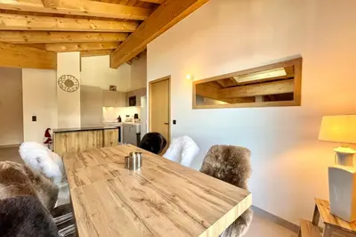 a dining room with a wooden table and chairs at Comfortable stay 200m from the ski lifts in Combloux