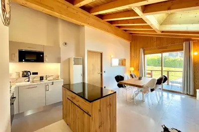 a kitchen and dining room with a table and chairs at Comfortable stay 200m from the ski lifts in Combloux