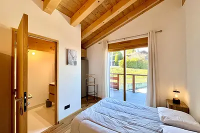 a bedroom with a bed and a door to a balcony at Comfortable stay 200m from the ski lifts in Combloux