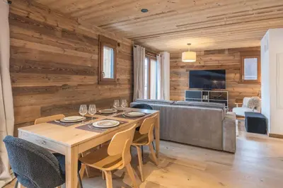 a dining room with a table and a couch at Appartement Jorat - Welkeys in Megève