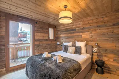 a bedroom with a large bed in a wooden room at Appartement Jorat - Welkeys in Megève