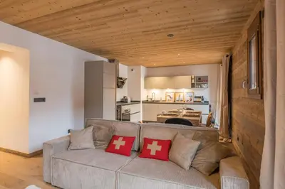 a living room with a couch and a kitchen at Appartement Jorat - Welkeys in Megève