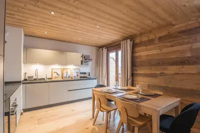 a kitchen and dining room with a table and chairs at Appartement Jorat - Welkeys in Megève