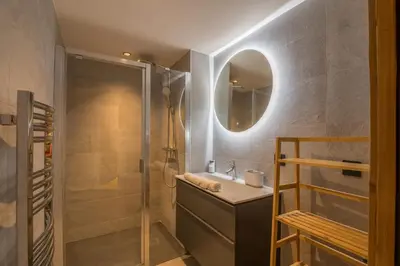 a bathroom with a shower and a sink and a mirror at Appartement Jorat - Welkeys in Megève