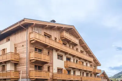 a building with wooden balconies on the side of it at Appartement Jorat - Welkeys in Megève