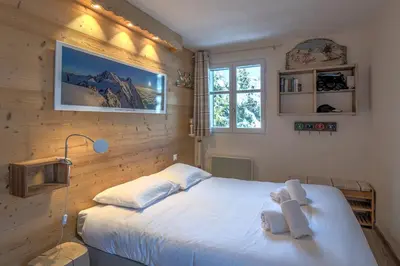 a bedroom with a bed with a teddy bear on it at Appartement La musardière - Welkeys in Megève
