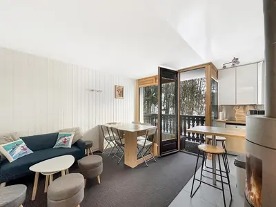 a kitchen and living room with a couch and a table at OEI30 - 3 pieces 6 pers proche centre station in Les Carroz d'Araches