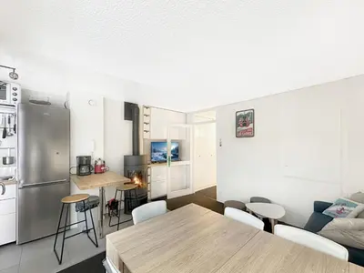 a kitchen and living room with a table and chairs at OEI30 - 3 pieces 6 pers proche centre station in Les Carroz d'Araches