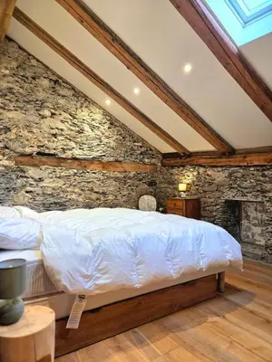 a bed in a room with a stone wall at Les Clarines des Contamines in Les Contamines-Montjoie
