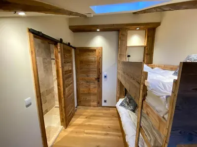 a room with two bunk beds and wooden walls at Les Clarines des Contamines in Les Contamines-Montjoie