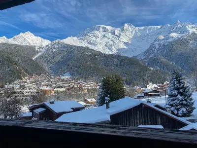 a town covered in snow with mountains in the background at Les Clarines des Contamines in Les Contamines-Montjoie