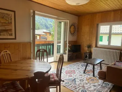 a living room with a wooden table and a window at La Flégère YourHostHelper in Chamonix-Mont-Blanc