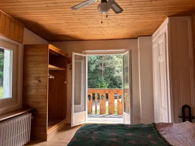 a bedroom with a bed with a ceiling fan and a window at La Flégère YourHostHelper in Chamonix-Mont-Blanc