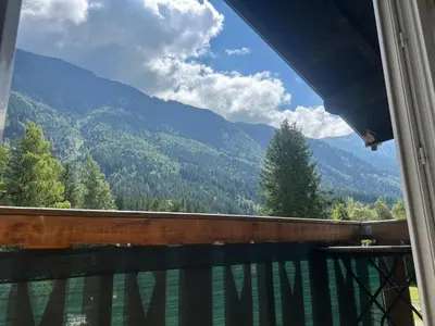 a balcony with a view of a house and mountains at La Flégère YourHostHelper in Chamonix-Mont-Blanc