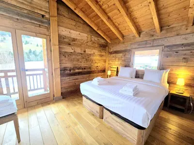 a bedroom with a bed in a wooden cabin at Chalet du Lay Côte 2000 ski in ski out in Megève