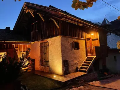 an old house with a wooden porch and a staircase at L'Ultime in Saint-Gervais-les-Bains