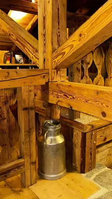 a large metal pot sitting in the corner of a wooden room at L'Ultime in Saint-Gervais-les-Bains