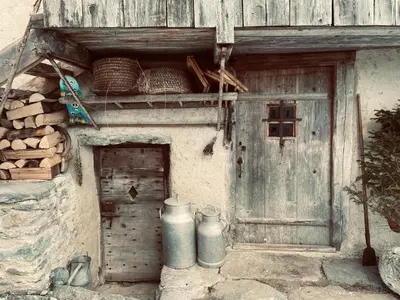 an old building with a door and two metal tanks at L'Ultime in Saint-Gervais-les-Bains