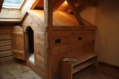 a large wooden dog house in a room at L'Ultime in Saint-Gervais-les-Bains