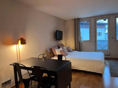 a bedroom with a bed and a table with chairs at Chamonix cœur de ville - Aiguille du midi in Chamonix-Mont-Blanc