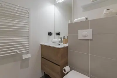 a white bathroom with a sink and a mirror at Les Ecrins de Kayla -Piscine - Sauna in Les Houches