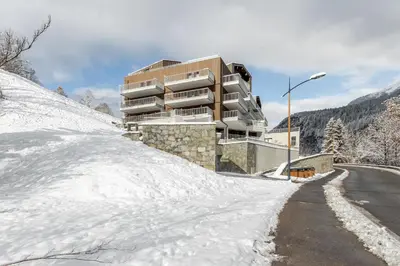 a snow covered road in front of a building at Les Ecrins de Kayla -Piscine - Sauna in Les Houches