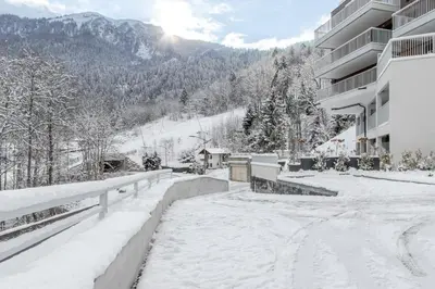 a snow covered street in front of a building at Kandahar de Kayla - Proche remontée - Espace bien-être in Les Houches