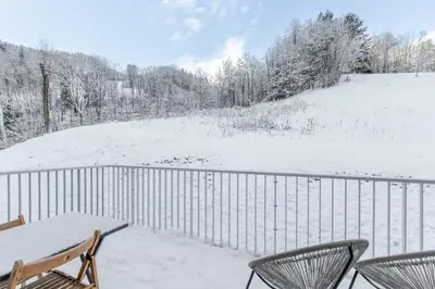 a balcony with a table and chairs in the snow at Kandahar de Kayla - Proche remontée - Espace bien-être in Les Houches