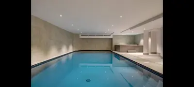 a swimming pool with blue water in a building at Kandahar de Kayla - Proche remontée - Espace bien-être in Les Houches