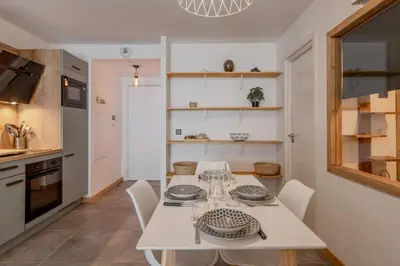a kitchen and dining room with a white table and chairs at Kandahar de Kayla - Proche remontée - Espace bien-être in Les Houches