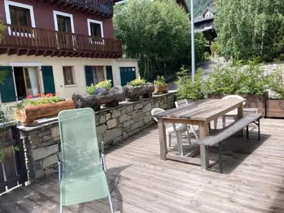 a wooden table and chairs on a wooden deck at Spacious 2 bedroom apt with terrace Chamonix center in Chamonix-Mont-Blanc